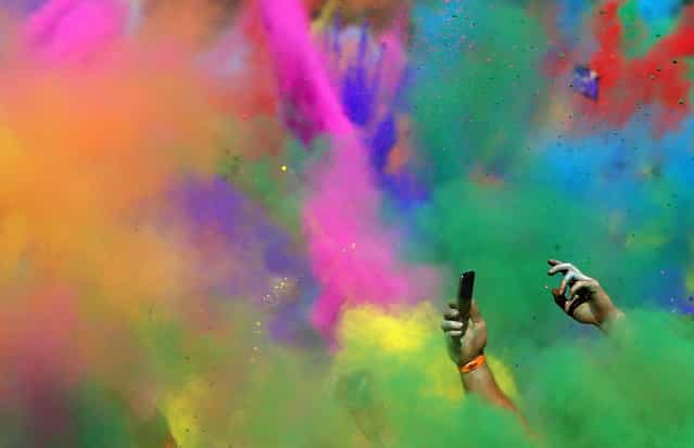 A man takes pictures at the finish line during the Colour Run at Centennial Park in Sydney August 25, 2013. According to organizers, 15,000 runners registered to complete the 5km (3 miles) course in Centennial Park on Sunday, being covered in blue, pink, orange and yellow powder on their way to the finish line. (Photo by Daniel Munoz/Reuters)