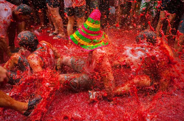 Revellers celebrate covered by tomato pulp while participating the annual Tomatina festival on August 28, 2013 in Bunol, Spain. An estimated 20,000 people threw 130 tons of ripe tomatoes in the world's biggest tomato fight held annually in this Spanish Mediterranean town. (Photo by David Ramos/Getty Images)