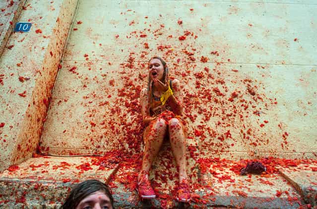 Revellers celebrate covered by tomato pulp while participating the annual Tomatina festival on August 28, 2013 in Bunol, Spain. An estimated 20,000 people threw 130 tons of ripe tomatoes in the world's biggest tomato fight held annually in this Spanish Mediterranean town. (Photo by David Ramos/Getty Images)
