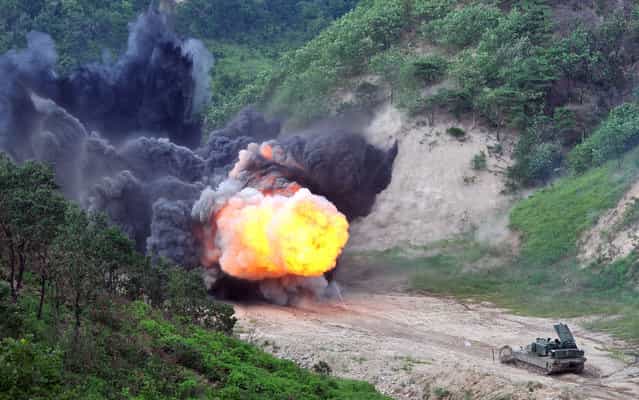 A US Army Assault Breacher Vehicle (ABV) fires the linear demolition charge system during a demonstration at Rodriguez Live Fire Complex in Pocheon, 65 kms northeast of Seoul, on August 14, 2013. A total of six ABVs, a highly mobile and heavily armored minefield and complex obstacle clearing system, were dispatched to South Korea in this year. (Photo by Jung Yeon-Je/AFP Photo)