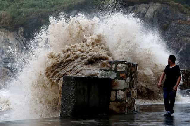 A man looks back at a surging wave as Typhoon Trami approaches China, in Wenling, Zhejiang province, August 21, 2013. Trami, the 12th typhoon to hit China this year, struck east China's Fujian Province on Thursday, local meteorological authorities said. Picture taken August 21, 2013. (Photo by Reuters/Stringer)