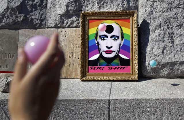 A participant throws a ball towards a picture depicting Russian President Vladimir Putin with make-up during the Prague Pride Parade, where several thousand people marched through Prague's city center in support of gay rights, on August 17, 2013. (Photo by David W. Cerny/Reuters)