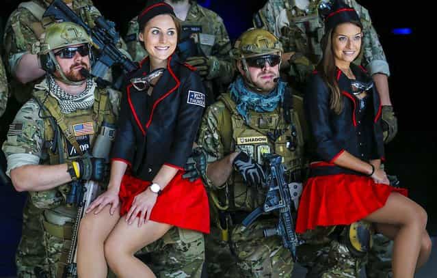 Men dressed as soldiers pose with models before the opening of the Gamescom 2013 fair in Cologne,Germany, on August 23, 2013. The Gamescom convention is Europe's largest video games trade fair. (Photo by Ina Fassbender/Reuters)