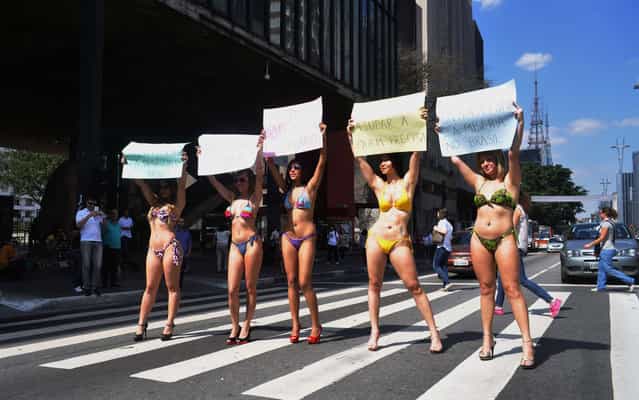 Five women wearing bikinis held a protest on August 23, 2013. The demonstration took place in the span MASP (Art Museum of São Paulo), in Paulista Avenue, in São Paulo. In one of the plates was written: [Let's end poverty and inequality in Brazil]. (Photo by J. Duran Machfee/Futura Press/Estadão Conteúdo)