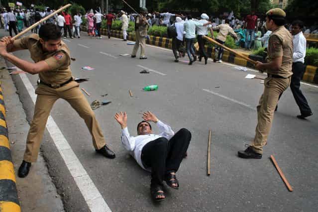 Indian police use batons to disperse a group of protestors who participate in a rally demanding caste-based affirmative action for promotions in government jobs in New Delhi, India, Monday, August 12, 2013. (Photo by AP Photo)