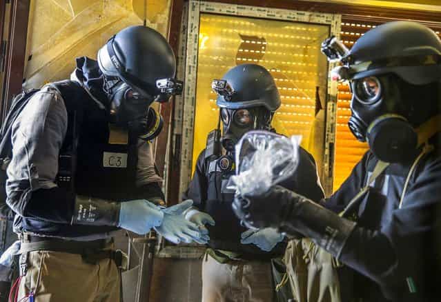 U.N. chemical weapons experts gather items at a site of alleged chemical weapons attack in the Ain Tarma neighborhood of Damascus, on August 29, 2013. (Photo by Mohamed Abdullah/Reuters)