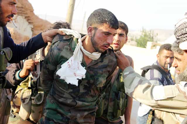 A Syrian soldier is captured by [Free Syrian Army] fighters during what the FSA say is an offensive against forces loyal to Syria's President Bashar al-Assad, in Qobtan village in Aleppo August 22, 2013. (Photo by Saad AboBrahim/Reuters)
