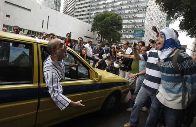 A passenger inside a taxi argues with a group of protesters who have blocked off an avenue during a demonstration against State Governor Sergio Cabral in downtown Rio de Janeiro, on August 15, 2013. (Photo by Pilar Olivares/Reuters)