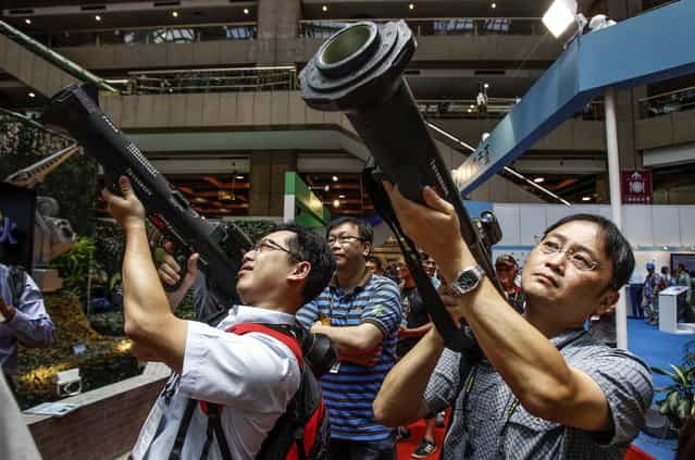 Visitors to the Taiwan Aerospace & Defense Technology Expo aim shoulder-fired Kestrel HEAT Rockets in Taipei, Taiwan, on August 16, 2013. (Photo by Wally Santana/Associated Press)