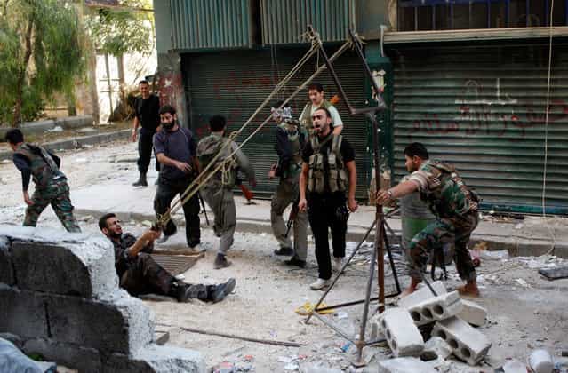 Members of the [Free Syrian Army] use a giant slingshot to launch a homemade bomb during clashes with pro-government soldiers in the city of Aleppo, October, 15, 2012. (Photo by Asmaa Waguih/Reuters)