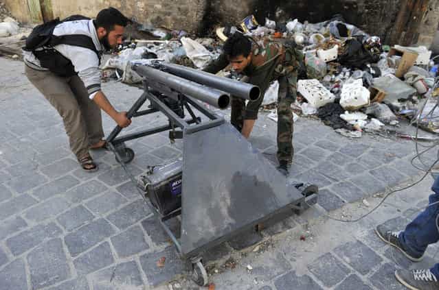 Syrian rebels adjust a homemade mortar launcher in the northern city of Aleppo, on October 16, 2012. (Photo by Tauseef Mustafa/AFP Photo)