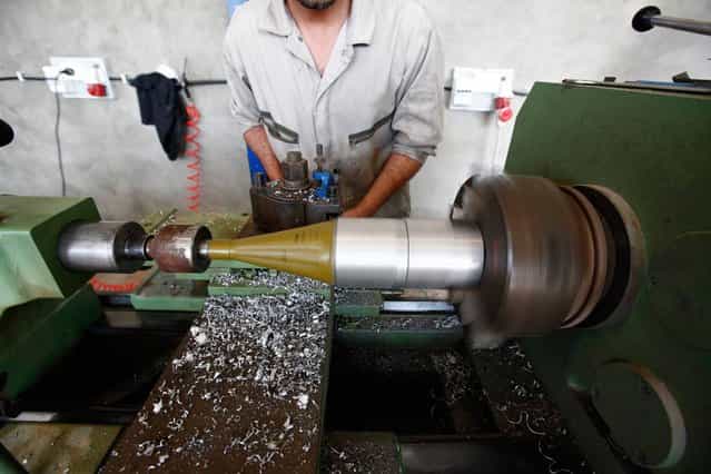 A Libyan rebel adds an aluminum ring to a used rocket-propelled grenade, which will be refitted with high explosives and reused, at a weapons workshop in Misurata on May 29, 2013. (Photo by Zohra Bensemra/Reuters)