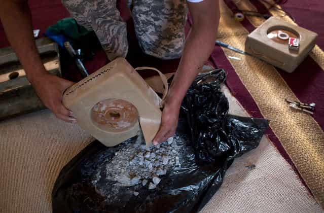 Rebel volunteer Ramzy Elshahiebi extracts elements from a mine while working to assemble homemade bombs in Benghazi on May 4, 2011. (Photo by Rodrigo Abd/AP Photo)