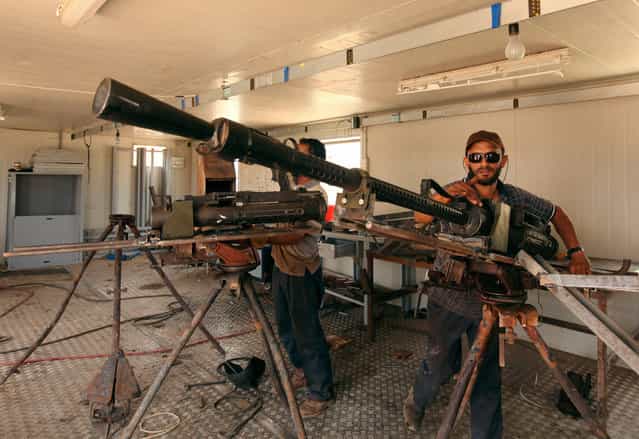A rebel soldier repairs weapons captured from forces loyal to Libyan leader Muammar el-Qaddafi, at a workshop in Benghazi, on June 13, 2013. (Photo by Esam Al-Fetori/Reuters)