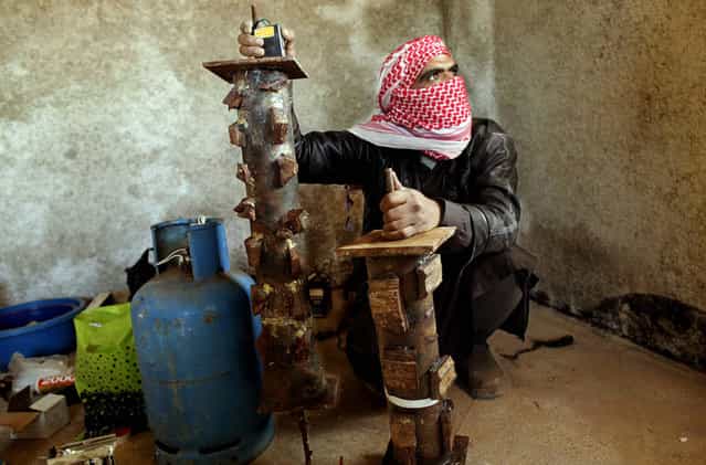 A bomb maker from Abu Suleiman's group of rebel fighters wires pipe bombs, which are detonated in specific areas to cut access to their mountainous stronghold in the northern Syrian province of Idlib, on March 20, 2012. Abu Suleiman, who finances the weapons for the unit which carries his name, has assembled one of the multitude of armed groups fighting the regime. (Photo by Frederic Lafargue/AFP Photo)