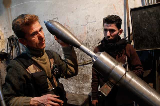 A [Free Syrian Army] fighter holds an improvised mortar shell inside a factory which previously manufactured steel and iron in Aleppo February 18, 2013. (Photo by Hamid Khatib/Reuters)