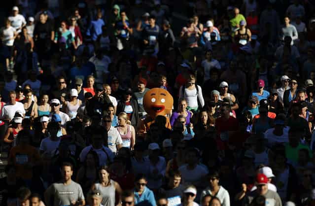 A participant dressed as a gingerbread man races at the annual [City 2 Surf Fun Run] in central Sydney August 11, 2013. According to organizers, more than 85,000 entered the race that covered 14 km (8.7 miles) from Sydney's central business district to Bondi Beach, raising funds for charity. (Photo by Daniel Munoz/Reuters)