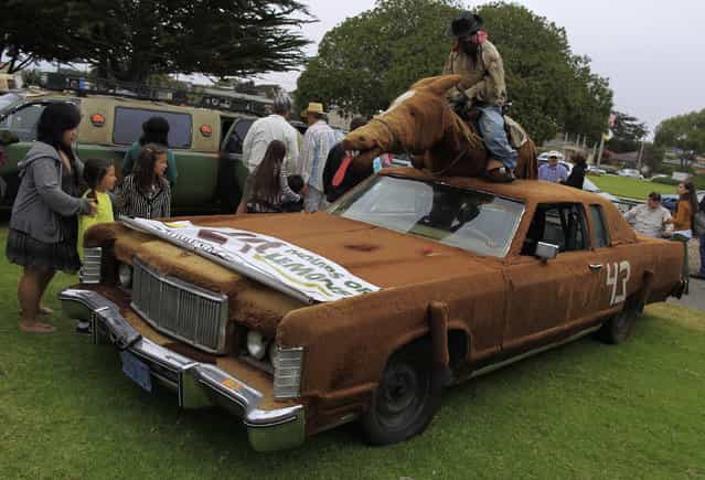 A 1975 Lincoln Towne Coupe customized with a horse and rider is displayed during the Concours d'Lemons in Seaside, California, August 17, 2013. The event, which highlights the [oddballs] of the automotive world, is held in conjunction with the Pebble Beach Automotive Week which includes the Concours d'Elegance. (Photo by Michael Fiala/Reuters)