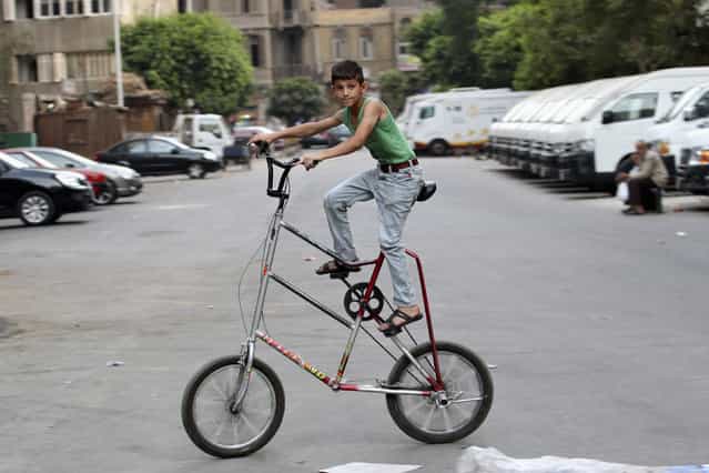 A Syrian boy living in Egypt rides his bicycle on a street in Cairo August 21, 2013. (Photo by Muhammad Hamed/Reuters)