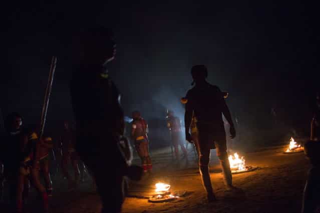 Waura Indians participate in the fire ritual during this year's [quarup], a ritual held over several days to honour in death a person of great importance to them, in Xingu National Park, Mato Grosso State, August 24, 2013. This year the Waura tribe honoured their late cacique (chief) Atamai, who died in 2012, for his work creating the Xingu Park and his important contribution in facilitating communication between white Brazilians and Indians. (Photo by Ueslei Marcelino/Reuters)