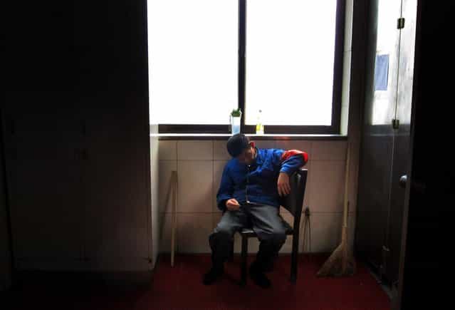 A cleaner sleeps while sitting on a chair at the Beijing West railway station October 28, 2012. (Photo by David Gray/Reuters)