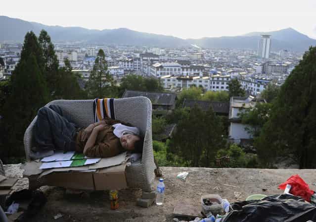 A garbage collector sleeps on a couch on the edge of a hilly road in Lijiang, Yunnan province, August 2, 2013. (Photo by Reuters/Stringer)