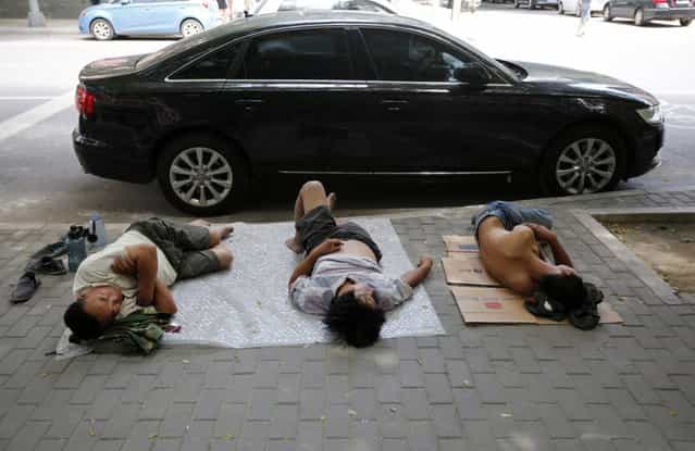 People take a nap on a street in Beijing July 4, 2013. (Photo by Kim Kyung-Hoon/Reuters)