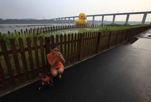 A television journalist does her make-up before reporting about an inflated Rubber Duck by Dutch conceptual artist Florentijn Hofman floating on a lake at the venue of the 9th China International Garden Expo in Beijing, September 6, 2013. The 18-metre-high inflatable sculpture, which made its first public appearance in the city on Friday, will be shown at the expo until September 23, after which it will be transported to the Summer Palace for display for another month, local media reported. (Photo by Petar Kujundzic/Reuters)