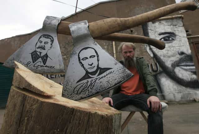 Russian artist Vasily Slonov poses for a picture with axes engraved with portraits of Russian President Vladimir Putin and Soviet leader Josef Stalin, during a presentation of his new art project [History of Russia, 20th century – from Lenin to Putin] at the courtyard of the Museum Center in Russia's Siberian city of Krasnoyarsk September 2, 2013. The artist has chemically engraved portraits of nine Soviet and Russian political figures on a series of butchers' axes. (Photo by Ilya Naymushin/Reuters)