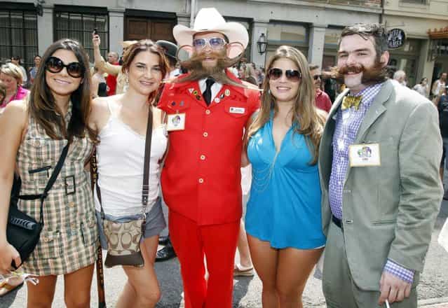 Tourists Elaine Oliveira, Zuleika Riveron and Daniele Alfonso pose with contestants Paul Roof of Charleston, South Carolina and Derek Nehrbass of New Orleans during a parade through the French Quarter kicking off the fourth annual Just For Men National Beard and Moustache Championships Saturday, September 7, 2013 in New Orleans. Contestants competed in 18 different categories including Dali, full beard natural and sideburns. (Photo by Susan Poag/AP Photo)