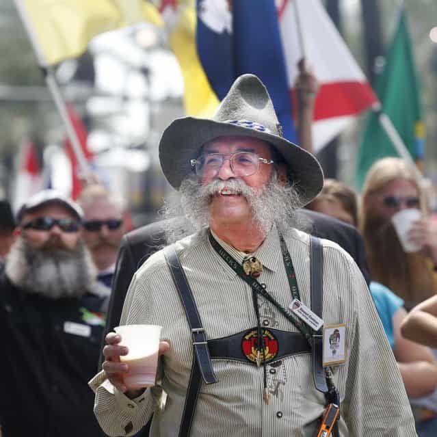 Stewart Eastman of Abita Springs, Louisiana enjoys a beer while parading through the French Quarter to kick off the fourth annual Just For Men National Beard and Moustache Championships Saturday, September 7, 2013 in New Orleans. Contestants competed in 18 different categories including Dali, full beard natural and sideburns. (Photo by Susan Poag/AP Photo)