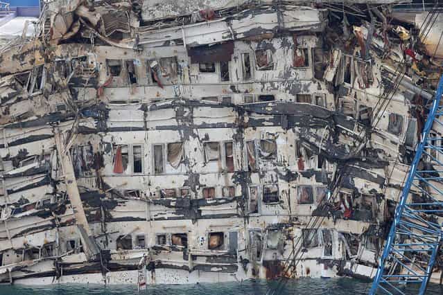 A detail of the previously submerged side of the Costa Concordia is seen after it was lifted upright, on the Tuscan Island of Giglio, Italy, Tuesday, September 17, 2013. The crippled cruise ship was pulled completely upright early Tuesday after a complicated, 19-hour operation to wrench it from its side where it capsized last year off Tuscany, with officials declaring it a [perfect] end to a daring and unprecedented engineering feat. (Photo by Andrea Sinibaldi/AP Photo/Lapresse)