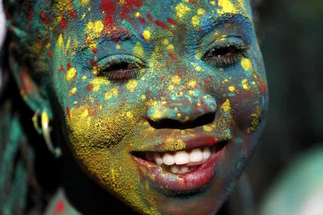 A woman, with her face covered with colored powders, dances during the Holi Festival of Colors in Lisbon, Sunday, September 15 2013. The festival, which is mainly celebrated during the Hindu spring festival Holi in some regions of India and Nepal, has become popular among people in other communities. (Photo by Francisco Seco/AP Photo)
