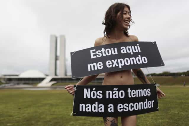 A member of the non-governmental organisation Avaaz takes part in a protest against the Brazilian Senate, calling to abolish the secret ballot on key votes, in front of the National Congress in Brasilia September 18, 2013. Posters in Portuguese read, [Here I am exposed, we have nothing to hide]. (Photo by Ueslei Marcelino/Reuters)