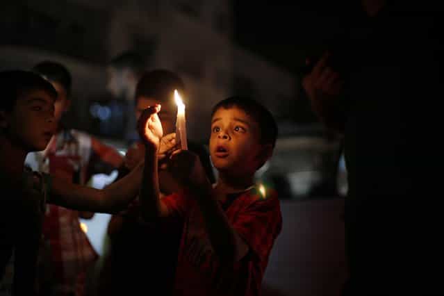 Palestinian children light candles during a protest against power cuts and the blockade on the Gaza Strip, in Gaza September 19, 2013. Israel imposed a blockade on Gaza in 2007 after its enemy, Islamist group Hamas, seized control of the territory in a brief civil war with Western-backed Palestinian President Mahmoud Abbas's Fatah party. (Photo by Suhaib Salem/Reuters)