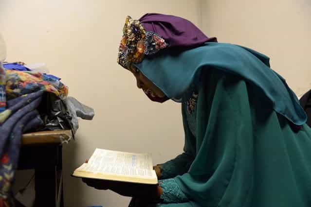 Contestant of the Muslimah World 2013, Obabiyi Aishah Ajibola of Nigeria, recites a copy of the Koran while contestants wait for a grand final during the Muslimah World competition in Jakarta on September 18, 2013. (Photo by Adek Berry/AFP Photo)
