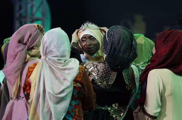 Nigerian Obabiyi Aishah Ajibola (C) is congratulated by fellow finalists after being named World Muslimah 2013 during the third Annual Award of World Muslimah in Jakarta September 18, 2013. Twenty Muslim women from Indonesia, Malaysia, Brunei Darussalam and Nigeria competed on Wednesday in the finals of the pageant, held exclusively for Muslim women, which assessed not only the contestants' appearances but also their piety and religious knowledge. (Photo by Reuters/Beawiharta)