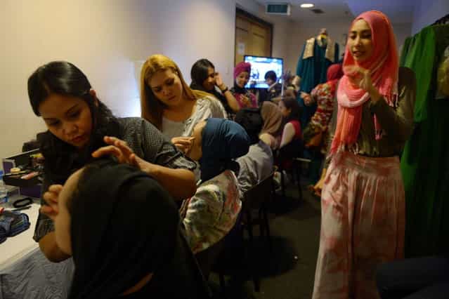 Contestants of the Muslimah World 2013 have their make-up done as they prepare for a grand final during the Muslimah World competition in Jakarta on September 18, 2013. (Photo by Adek Berry/AFP Photo)