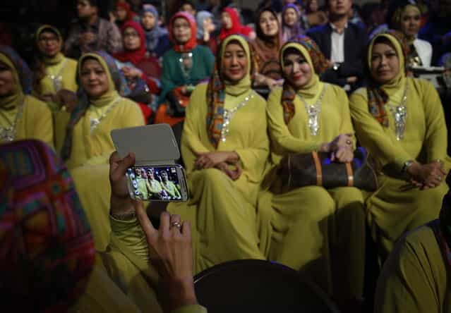 Members of the audience pose for a photo during the third Annual Award of World Muslimah in Jakarta September 18, 2013. Twenty Muslim women from Indonesia, Malaysia, Brunei Darussalam and Nigeria competed on Wednesday in the finals of the pageant, held exclusively for Muslim women, which assessed not only the contestants' appearances but also their piety and religious knowledge. (Photo by Reuters/Beawiharta)