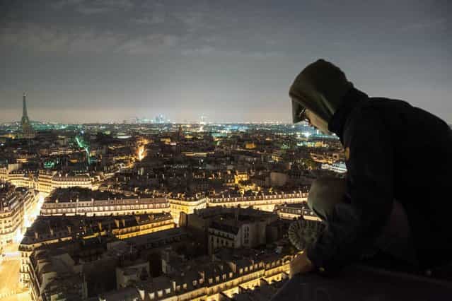 Urban explorer Bradley Garrett looks down at the streets of Paris from the roof of Saint-Sulpice church, in the Luxembourg Quarter of the VIe arrondissement, in Paris. (Photo by Bradley L. Garrett/Barcroft Media)
