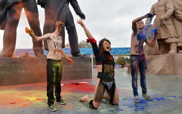 Activists of the Creative Youth organization throw colored powder to symbolize a rainbow during a Ukraine to EU protest in Kiev on September 24, 2013. Protesters called on joining European human values, for an end of homophobia in the country and to allow same-sex marriages. (Photo by Sergei Supinsky/AFP Photo)