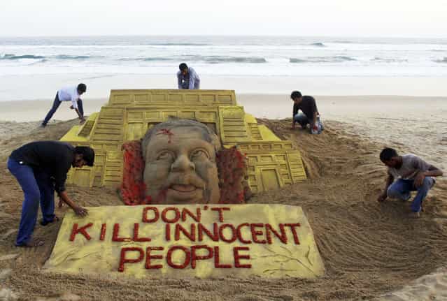 Indian sand artist Sudarshan Pattnaik, foreground left and his team pay tributes to the victims of the terror attack on a Kenya mall by creating a sand sculpture on the Bay of Bengal coast in Puri, Orissa state, India, Tuesday, September 24, 2013. (Photo by Biswaranjan Rout/AP Photo)