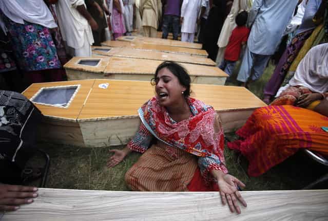 A Christian woman mourns next to the coffin of her brother, who was killed in a suicide attack on a church, in Peshawar September 22, 2013. A pair of suicide bombers blew themselves up outside a 130-year-old church in Pakistan after Sunday Mass, killing at least 56 people in the deadliest attack on Christians in the predominantly Muslim South Asian country. (Photo by Fayaz Aziz/Reuters)