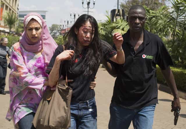An injured woman (C) is helped out of the Westgate Shopping Centre where gunmens went on a shooting spree, in Nairobi September 21, 2013. (Photo by Siegfried Modola/Reuters)