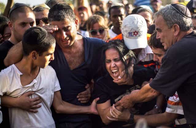 Smadar, mother of Israeli soldier, Staff Sergeant Gabriel Koby, mourns during his funeral at the military cemetery in Haifa, Israel, on September 23, 2013. Koby, 20, was shot and killed by an unknown gunmen in the biblical city of Hebron in the West Bank on Sunday, and troops are searching for the shooter, the military said. It was the second soldier killed since the weekend when a Palestinian killed an Israeli soldier with the intention of trading the body for his brother who is jailed for shooting attacks. (Photo by Ariel Schalit/Associated Press)