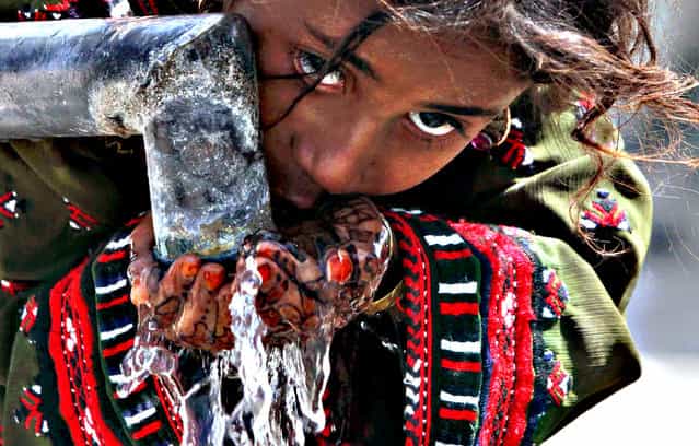 A girl affected from 7.7 magnitude earthquake drinks water from a community tap, in Awaran, Balochistan province, Pakistan, 26 September 2013. The death toll from a powerful 7.7 magnitude earthquake that struck south-western Pakistan on 24 September climbed to a total of so far 355 people with hundreds injured. A high number of causalities occured in the Awaran district of Balochistan province, which was the epicentre. The quake struck south and south-western Pakistan on 24 September afternoon and was felt as far away as the Indian capital New Delhi. (Photo by Shahzaib Akber/EPA)
