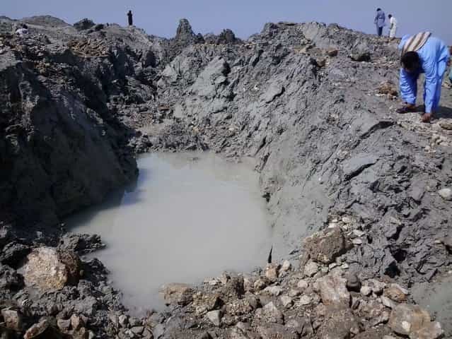 This photograph taken on September 25, 2013, shows Pakistani residents as they gather on an island that appeared some two kilometres off the coastline of Gwadar after an earthquake. A small island of mud and rock created by the huge earthquake that hit southwest Pakistan has fascinated locals but experts – who found methane gas rising from it – say it is unlikely to last long. The 7.7-magnitude quake struck on September 24, in Baluchistan's remote Awaran district, killing at least 271 people and affecting hundreds of thousands. (Photo by Behram Baloch/AFP Photo)