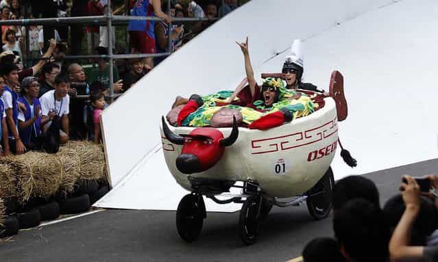 Drivers of a traditional Taiwanese beef noodle soup [soapbox] racer maneuver through the downhill course of the Red Bull Soapbox Race in Taipei, Taiwan, on September 29, 2013. Racers judged on time and creativity competed for the top prize: a trip to the November 2013 Macau Grand Prix. (Photo by Wally Santana/Associated Press)