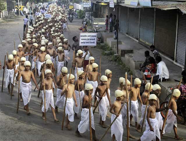 Indian children dressed as Mahatma Gandhi walk during a procession to mark Gandhi's birth anniversary in Kolhapur, Maharashtra state, India, Wednesday, October 2, 2013. (Photo by AP Photo)