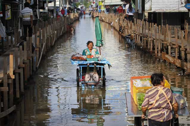 Food vendors push their carts through a flooded street of Sena district in Ayutthaya province October 2, 2013. More than 2 million people have been affected by flooding in Thailand, officials said on Monday, while authorities warned that more heavy rains could inundate the country's northeast but offered assurances that there would be no repeat of 2011 when floodwaters reached central industrial areas and near Bangkok. (Photo by Chaiwat Subprasom/Reuters) Food vendors push their carts through a flooded street of Sena district in Ayutthaya province October 2, 2013. More than 2 million people have been affected by flooding in Thailand, officials said on Monday, while authorities warned that more heavy rains could inundate the country's northeast but offered assurances that there would be no repeat of 2011 when floodwaters reached central industrial areas and near Bangkok. (Photo by Chaiwat Subprasom/Reuters)